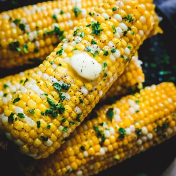 freshly cooked corn with butter and herbs.