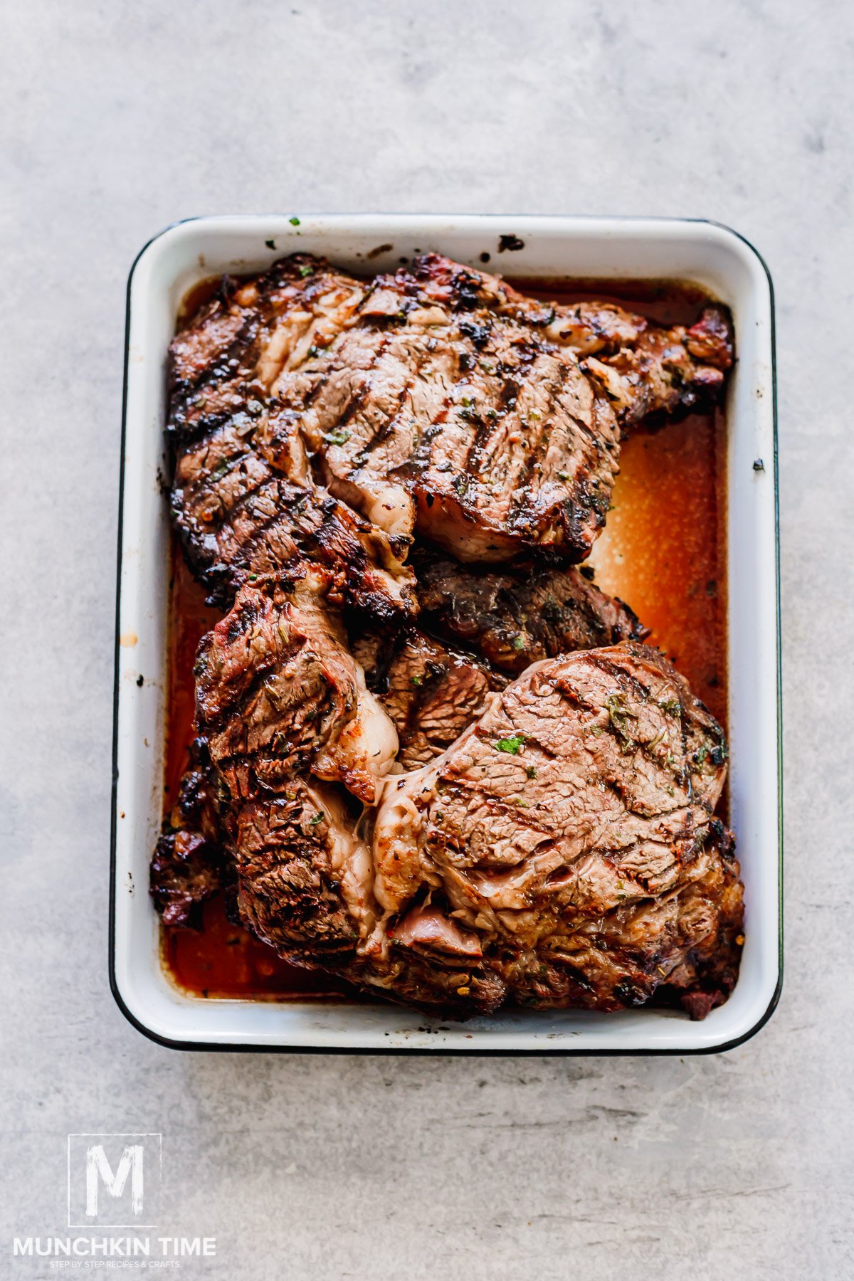 grilled ribeye steaks resting before being sliced.