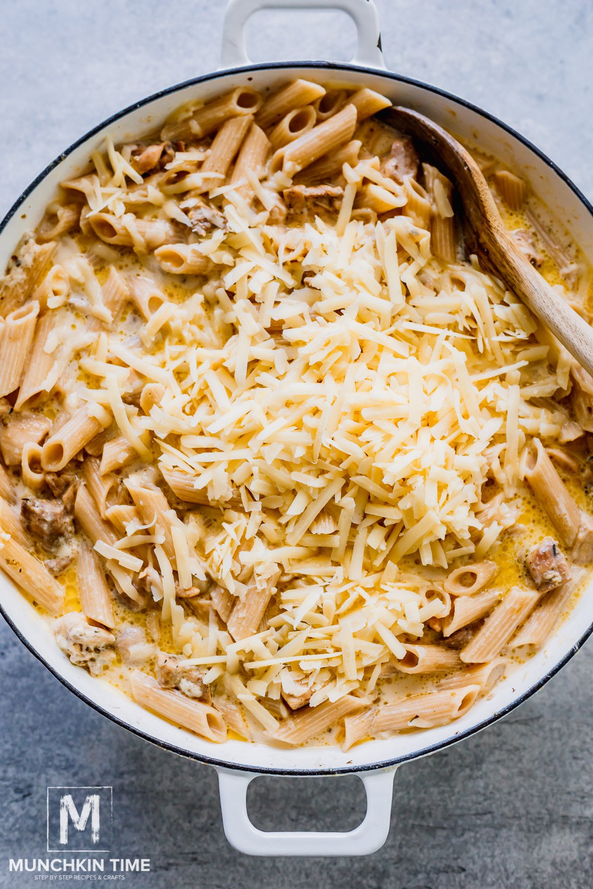 parmesan cheese in the skillet of pasta and chicken.