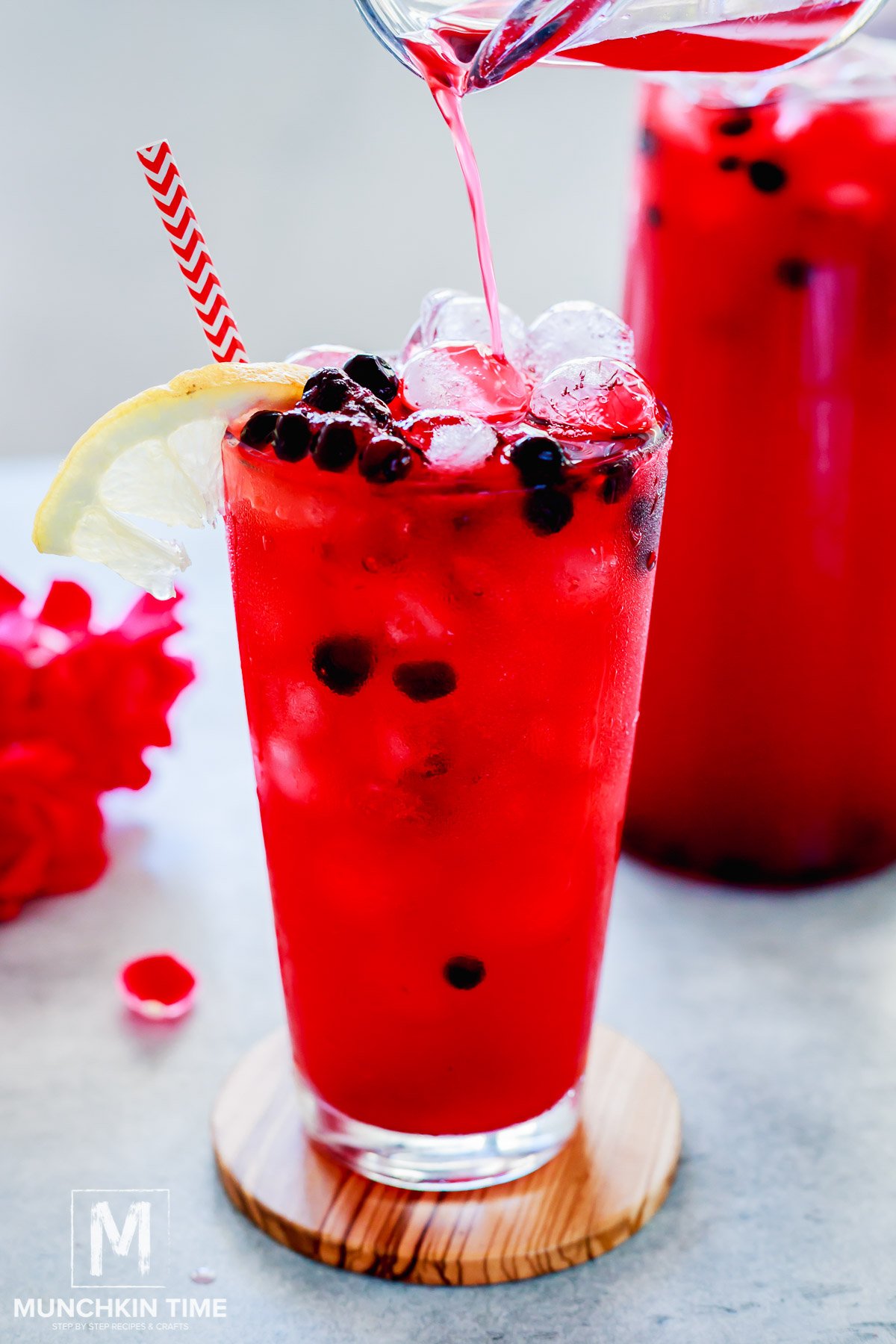 Huckleberry Lemonade in a tall glass with ice and huckleberry berries.