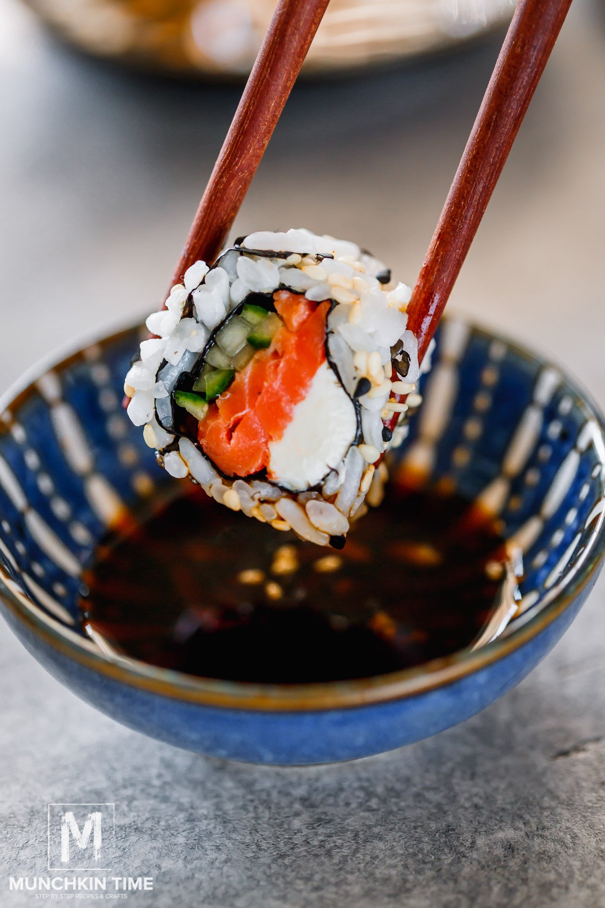 Philadelphia Roll dipped in a soy sauce.