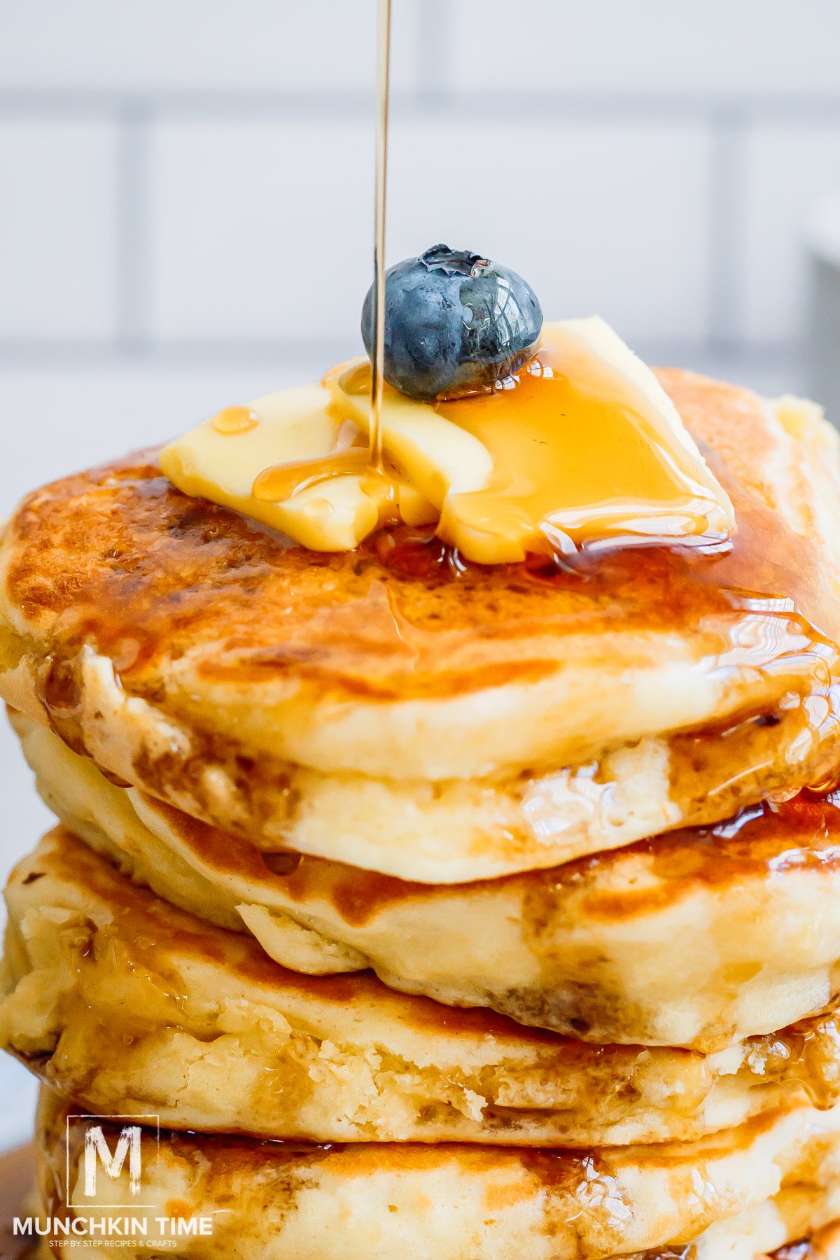 maple syrup pouring down a Sourdough Discard Pancake stack.