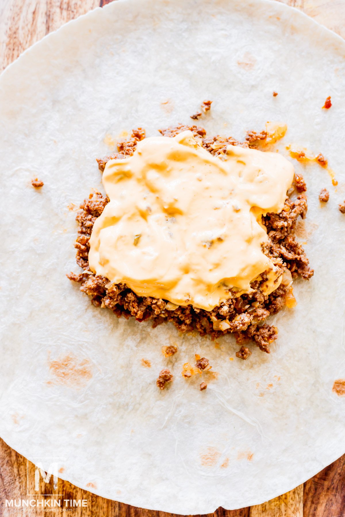 Ground cooked beef added to the large tortilla with con queso.