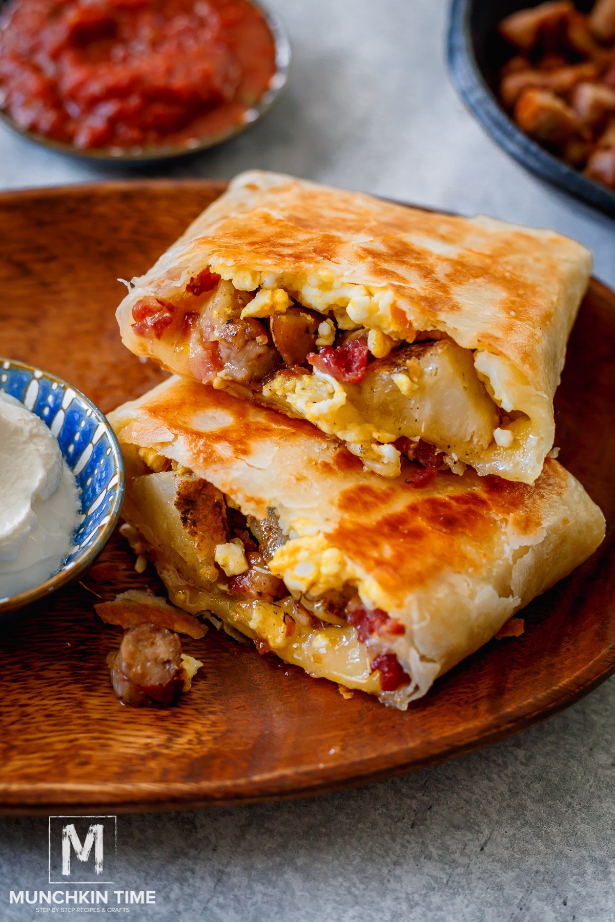 Bacon Egg and Cheese Breakfast Burrito cut in half on the plate.