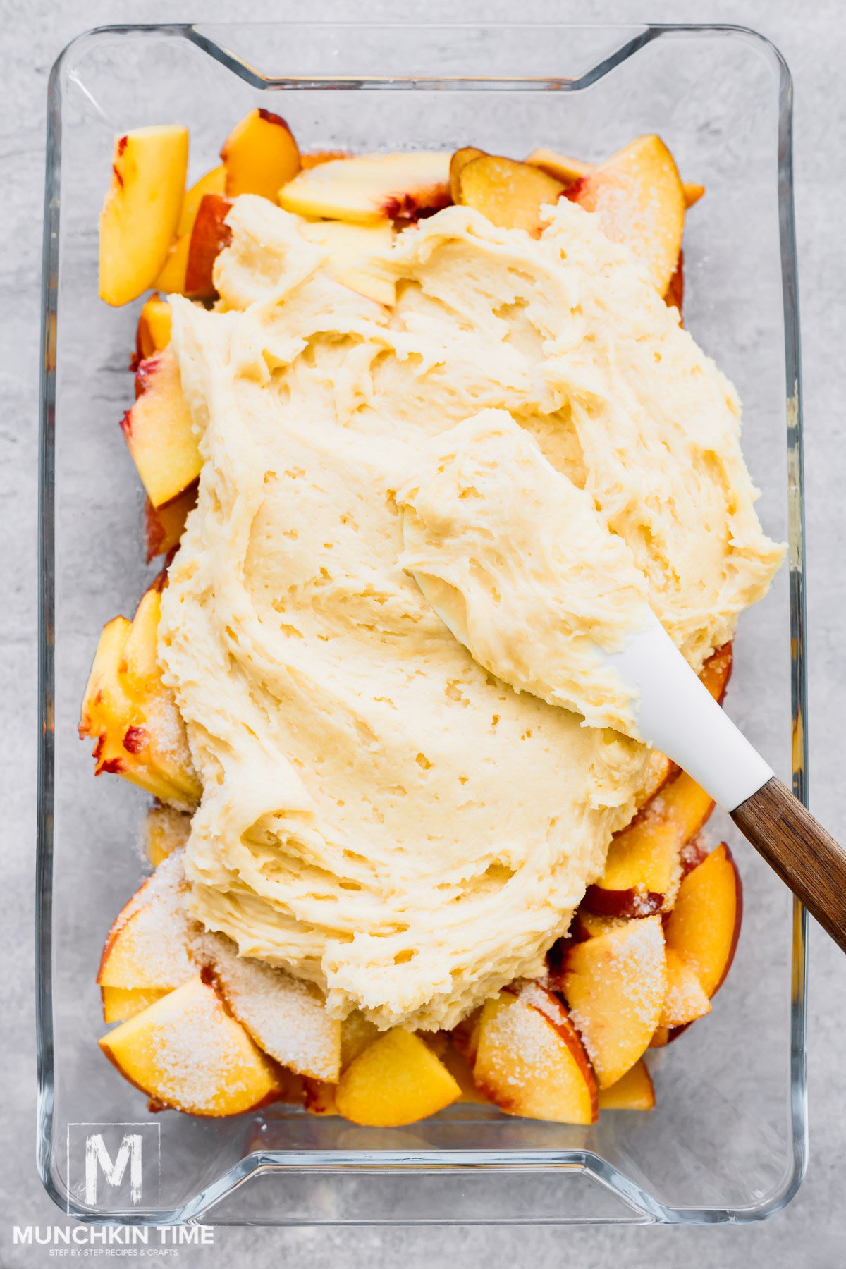 Cake batter added over the sliced peaches.