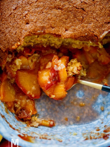 A spoonful of a Cake Peach Cobbler with Fresh Peaches.