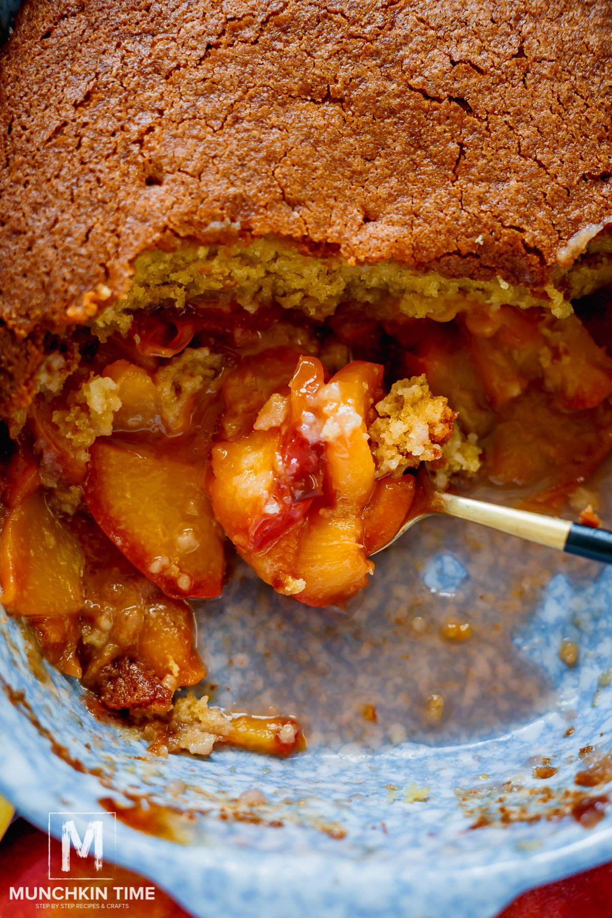 A spoonful of a Cake Peach Cobbler with Fresh Peaches.