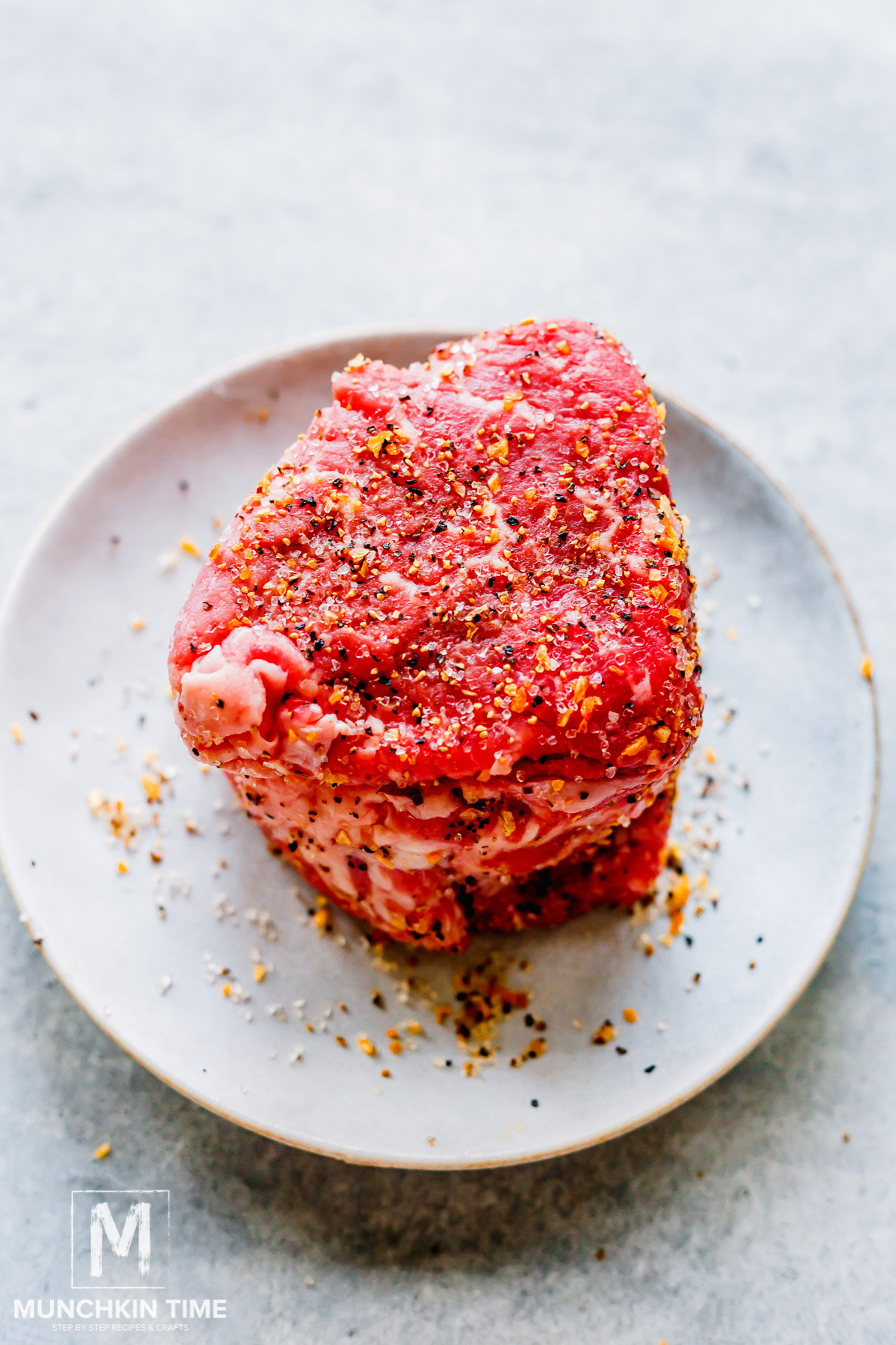 filet mignon seasoned with steak spice on a plate.