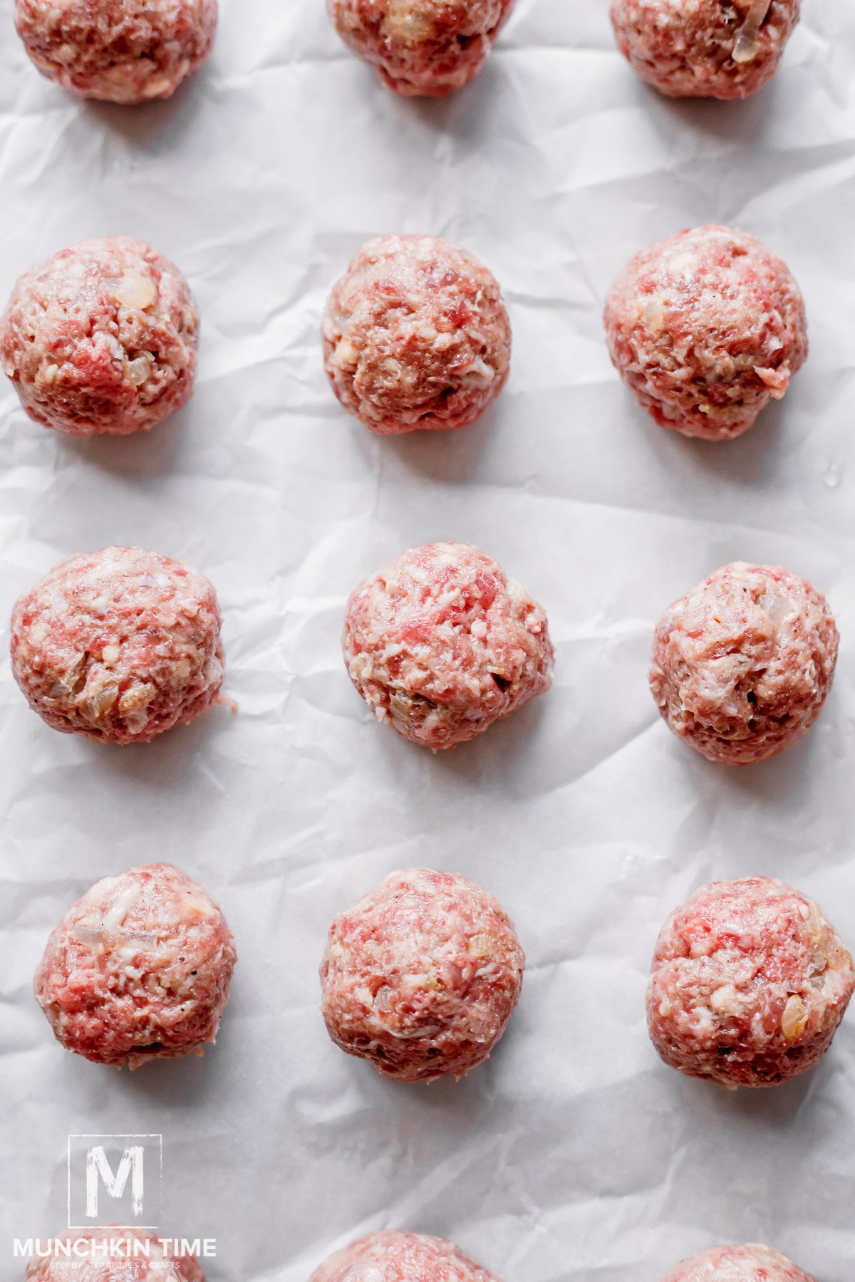 raw meatballs on a parchment paper.