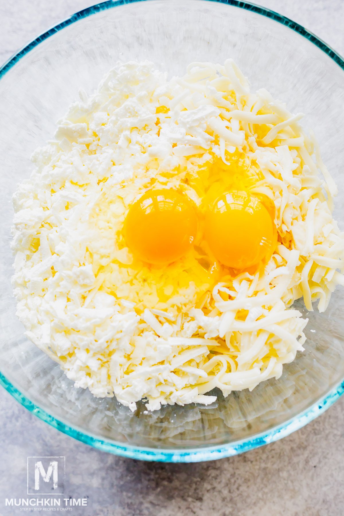 feta and mozzarella added to the bowl with eggs.