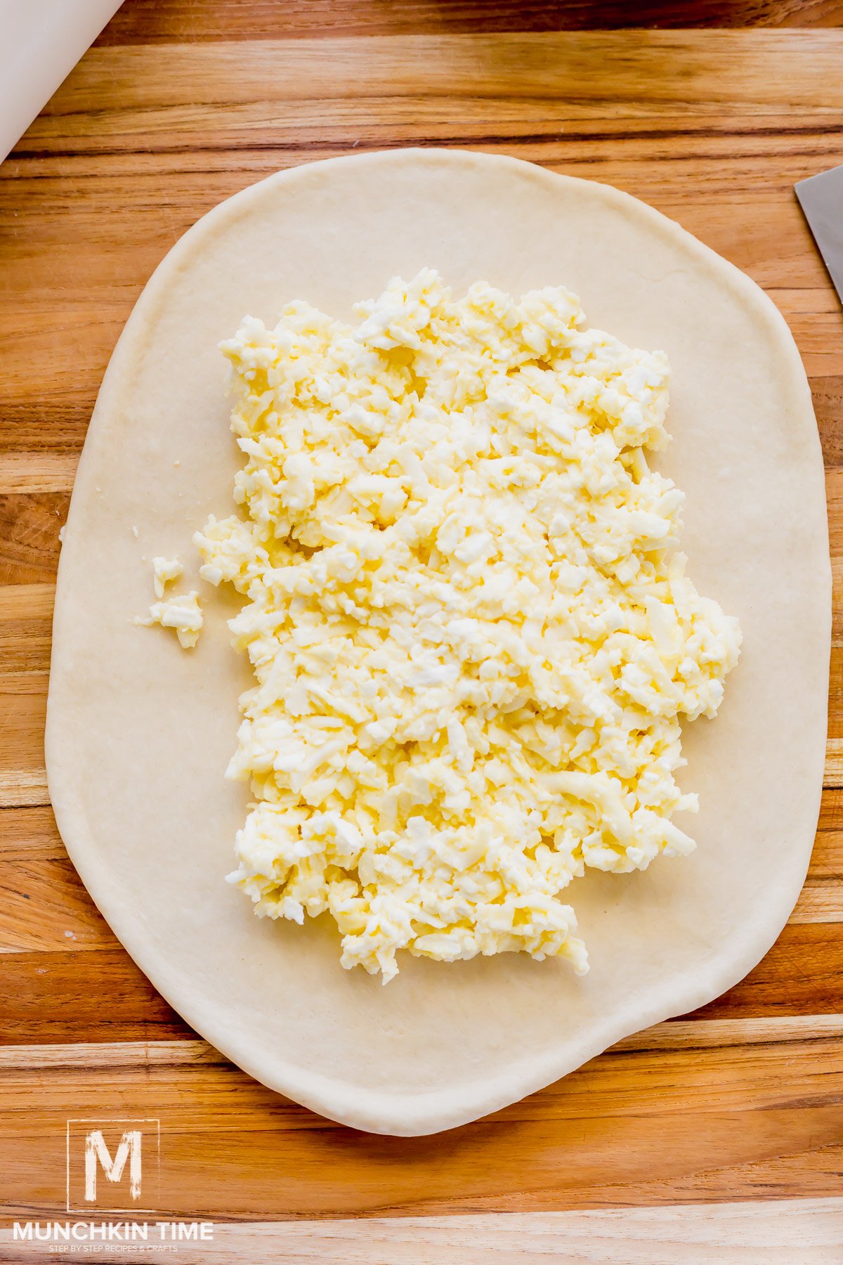 Cheese filling added to the center of the oval shape dough.