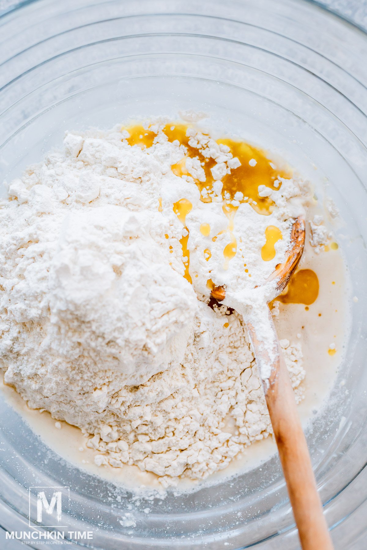 Combining flour salt and oil in a bowl with water and yeast.