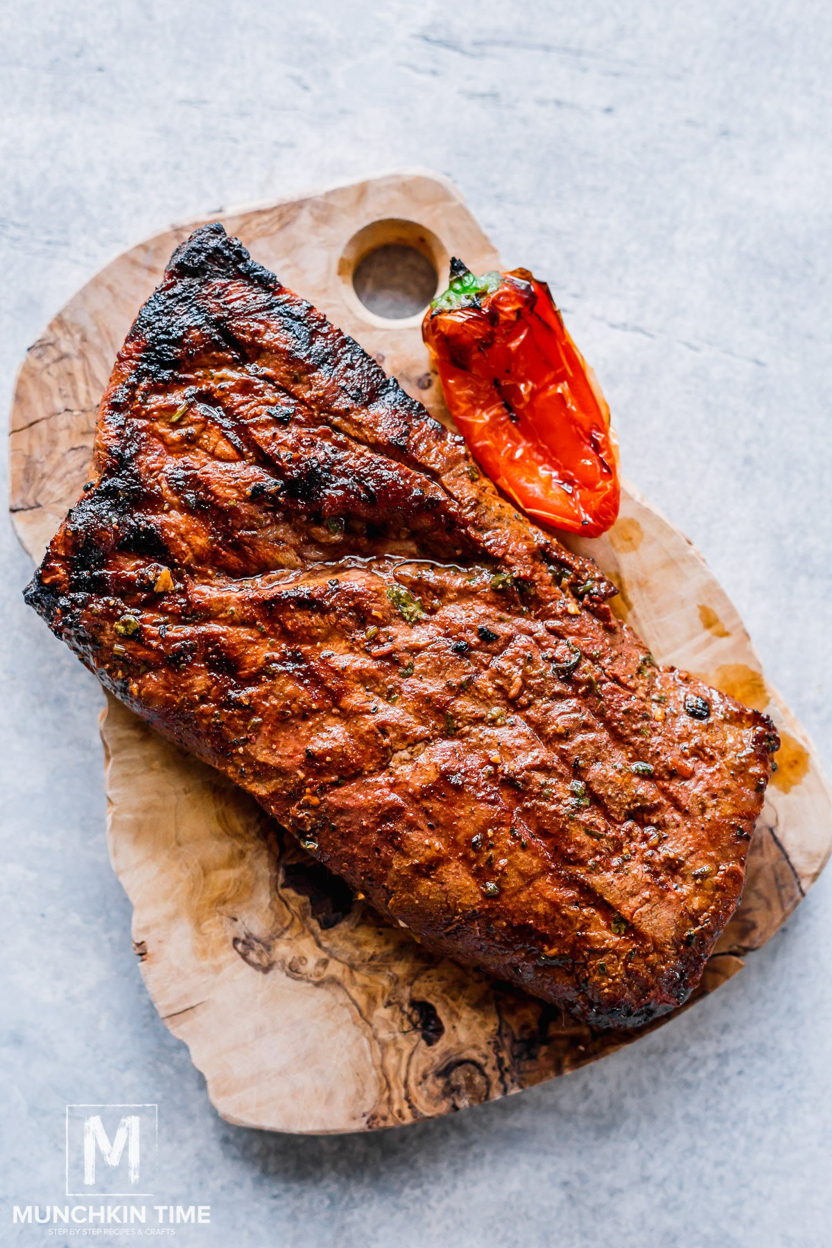 grilled steak on a cutting board resting.