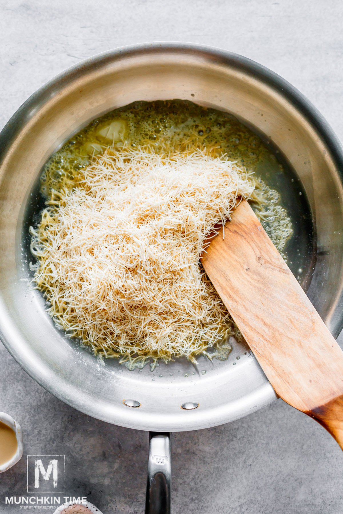 kataifi pastry added to the melted butter in the skillet.